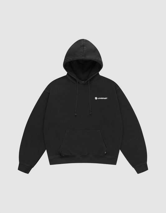 The LFDY Dealership Hooded by LIVE FAST DIE YOUNG is a black oversize-fit cotton sweatshirt with a front pocket, drawstrings, and a small white helmet graphic plus "LIVEFAST" text on the left chest. Set against a plain light gray background.
