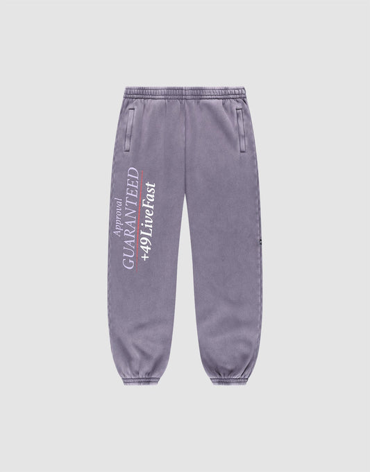 The LFDY Hotline Loose Jogger by LIVE FAST DIE YOUNG features a loose fit, elastic waistband, side pockets, and white vertical "GUARANTEED +49 Live Fast" print with smaller text on the left leg. | plain