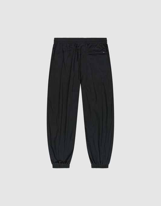 The LFDY Dealership Trackpants by LIVE FAST DIE YOUNG feature a black wide fit, polyamide material, elastic waistband and cuffs, and a left zip pocket. Shown laid flat on a light gray background.