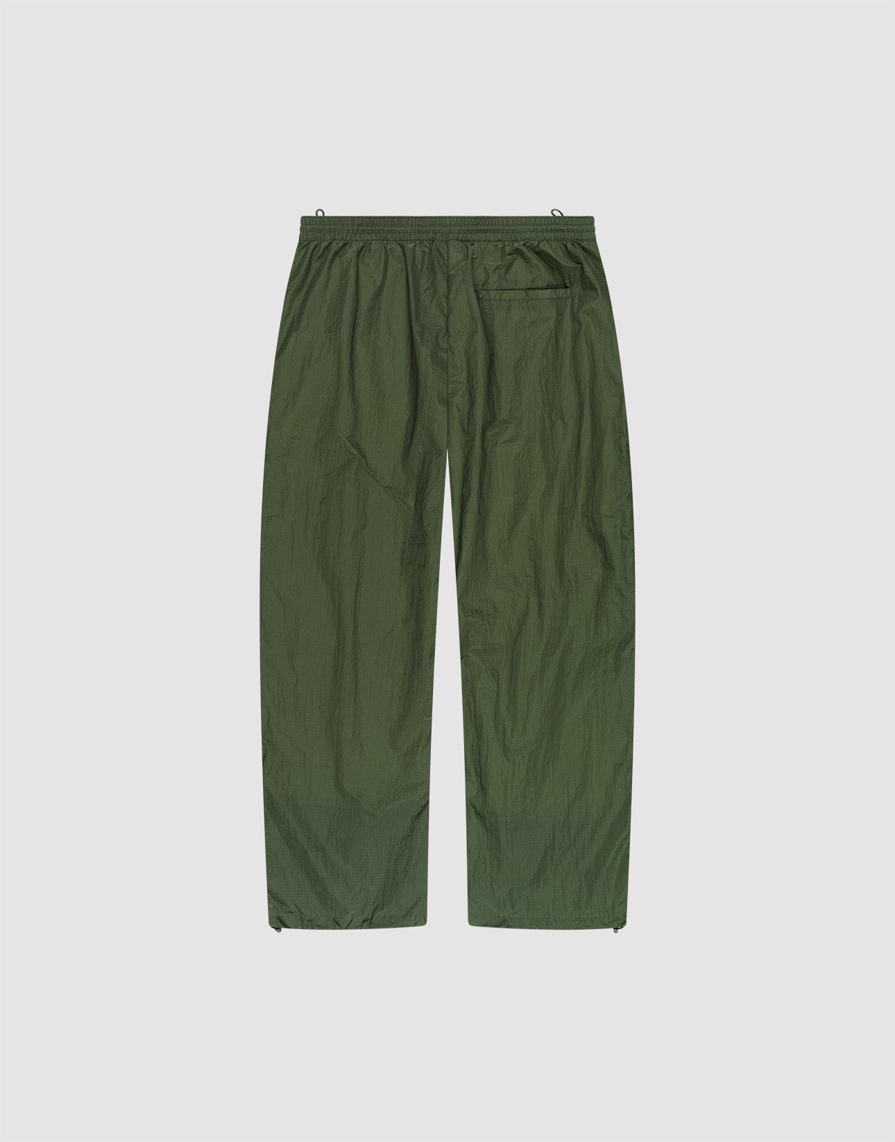 The LFDY Nylon Trackpants by LIVE FAST DIE YOUNG feature olive green, lightweight polyamide nylon, an elastic waistband, wide straight legs, and a single back pocket, shown flat on a plain white background.