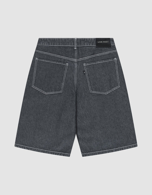 The LFDY Jorts by LIVE FAST DIE YOUNG are shown from the back, displaying a baggy fit, two large rear pockets with white stitching, and a black “LIVE FAST” Lederpatch on the waistband. The dark gray shorts are laid flat on a light background.