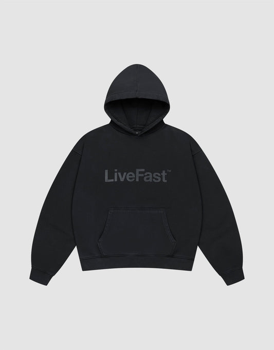 The Basic Livefast Hooded by LIVE FAST DIE YOUNG is an oversized black hoodie featuring a subtle "LiveFast" front print, crafted from soft cotton and shown against a plain light gray background. | plain