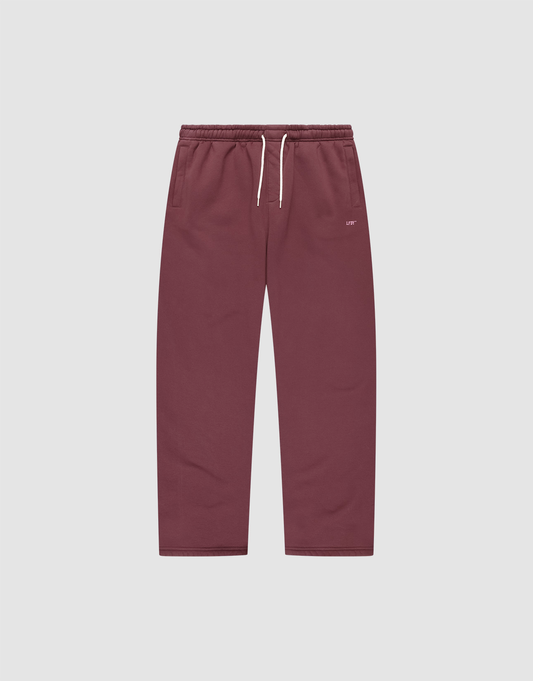 The Basic Wide Jogger by LIVE FAST DIE YOUNG features a burgundy color, elastic waistband, white drawstring, side pockets, and a small white LIVI logo-print on the left hip. The wide fit pants are shown laid flat on a light background. | plain