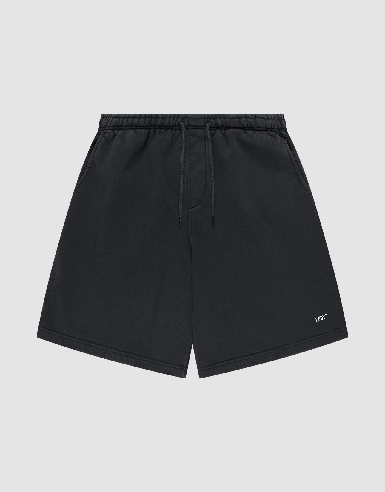 Basic Shorts by LIVE FAST DIE YOUNG in black, featuring an elastic waistband, side pockets, and a small white logo print on the lower left leg, shown against a plain light gray background. | plain