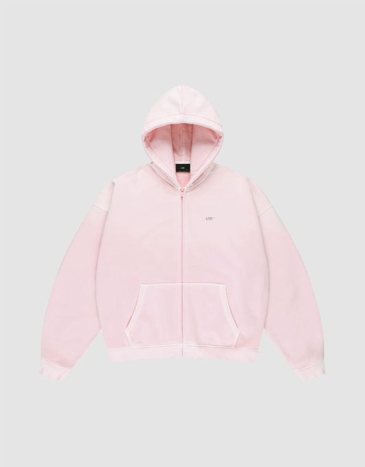The Basic Evidence Hooded Zip by LIVE FAST DIE YOUNG is a light pink zip-up sweatshirt with a hood, front pockets, a small LIFE logo on the left chest, and subtle LFDY-Branding, shown on a plain light gray background.