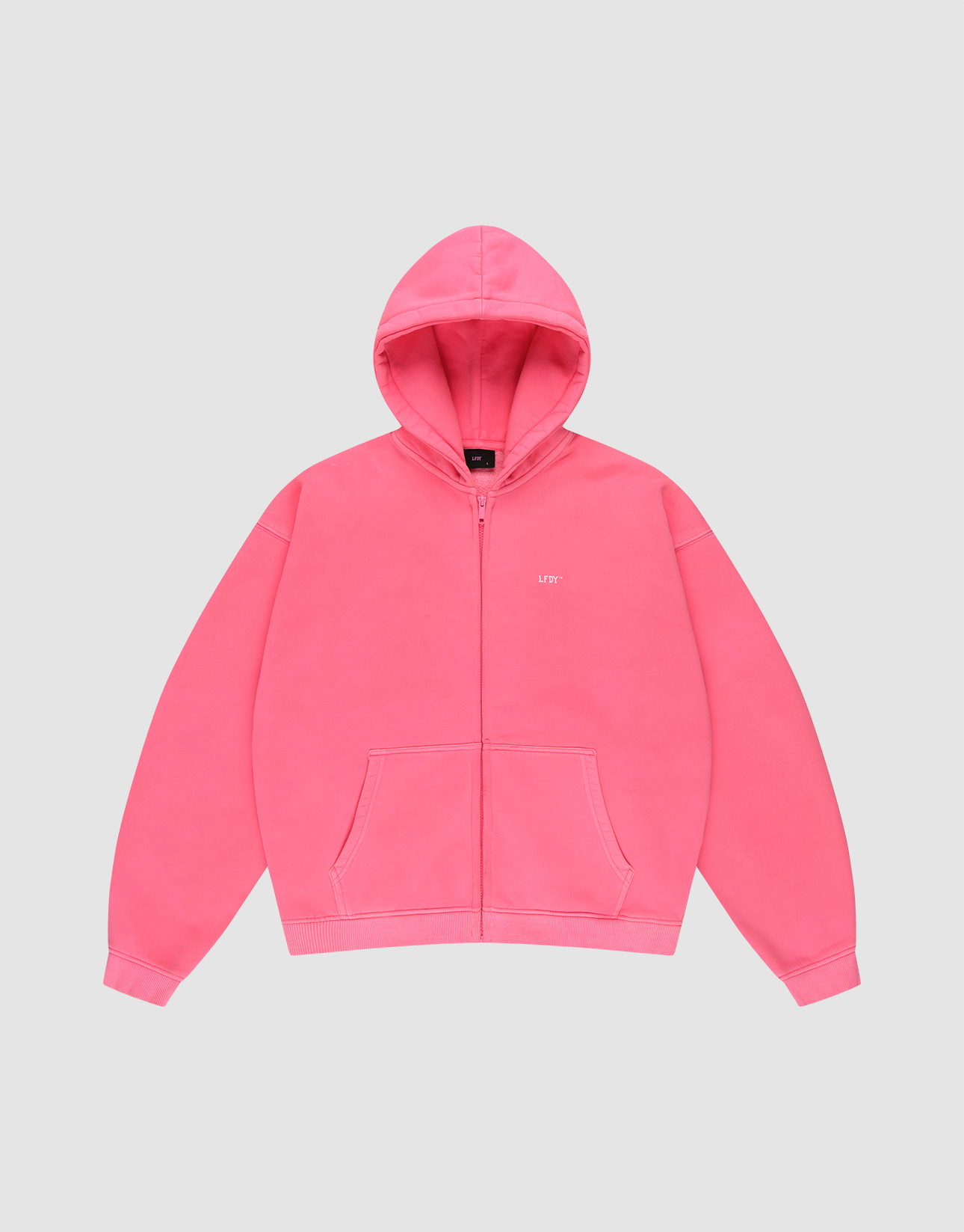 The LIVE FAST DIE YOUNG "Basic Hooded Zip" is a bright pink, oversize-fit zip-up hoodie with front pockets, a hood, and subtle white branding on the left chest, shown against a plain light gray background. | plain