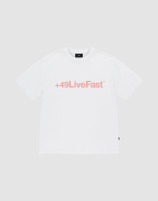 The Basic +49 Tee by LIVE FAST DIE YOUNG is an oversized white t-shirt made from 100% Baumwolle, featuring a bold pink +49LiveFast™ front print, displayed on a plain light gray background.