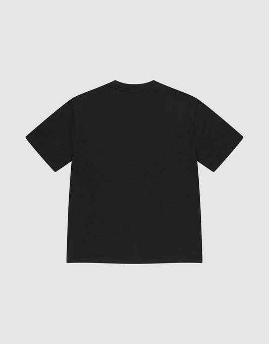 The LIVE FAST DIE YOUNG Basic Heavy Tee, an oversized black short-sleeve t-shirt made from 100% Baumwolle, is shown laid flat with the back facing up on a light gray background, featuring a subtle Flag-Label detail.