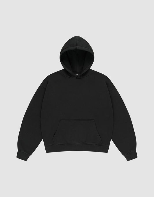 The LIVE FAST DIE YOUNG Basic Blank Hooded is an oversized black hoodie with long sleeves, a kangaroo pocket, ribbed cuffs and hem, made from a Baumwolle Polyester blend, shown on a light gray background. | plain