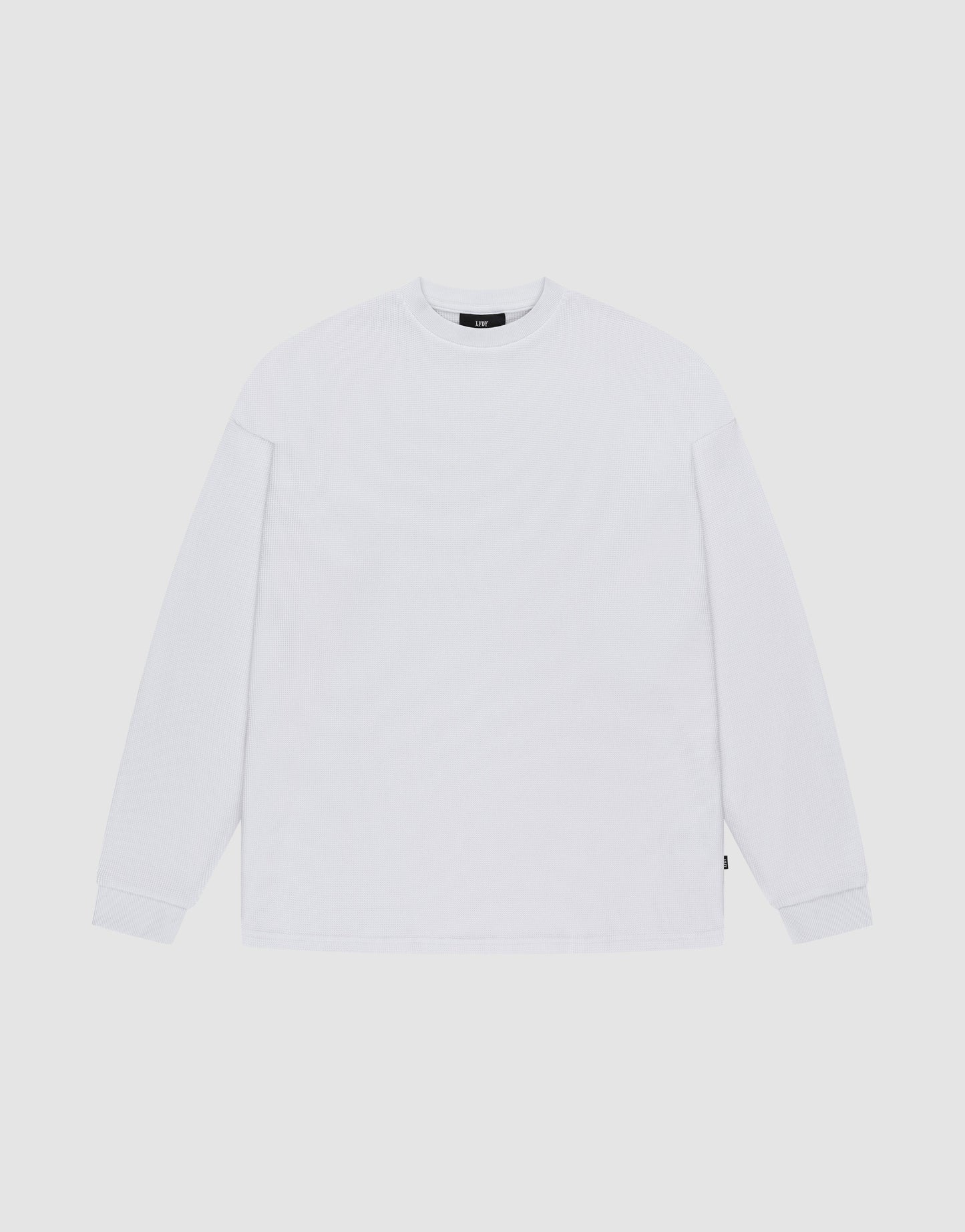 The LIVE FAST DIE YOUNG Blank Waffle Longsleeve, in Oversize Fit, is a plain white crew neck shirt with simple ribbed cuffs, made from 100% Baumwolle and featuring a minimal design without visible logos or patterns. | plain