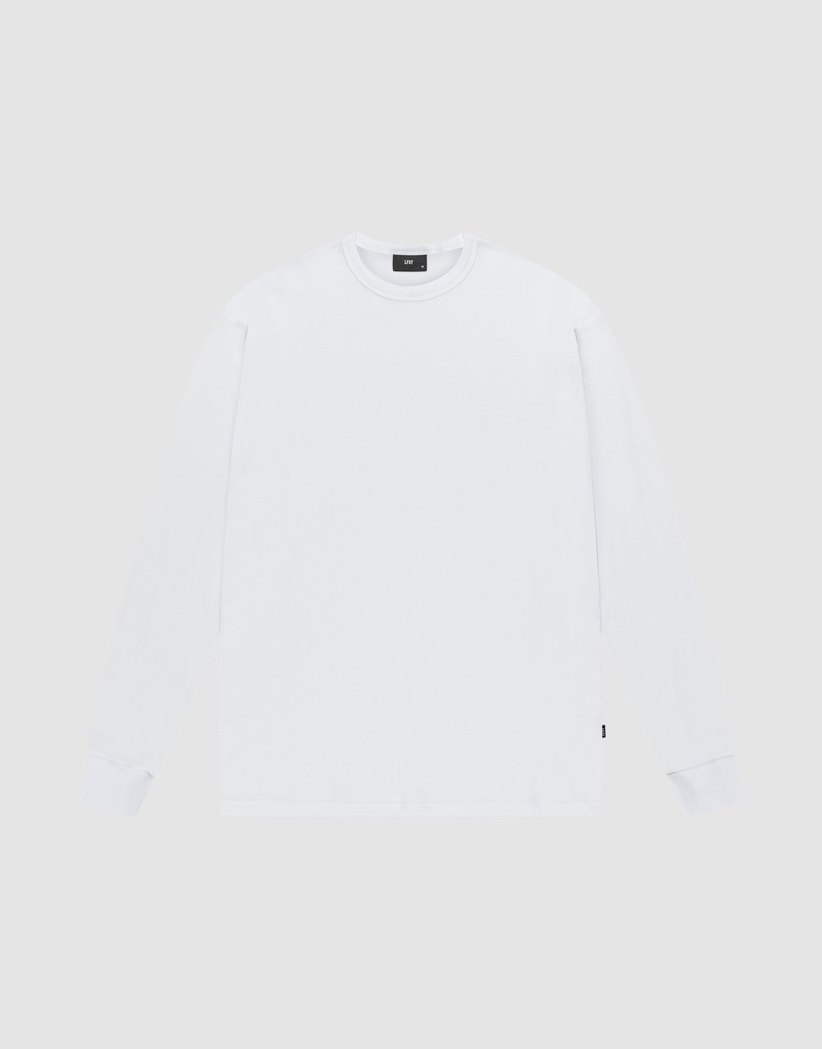 The LIVE FAST DIE YOUNG Blank Waffle Longsleeve is a white, oversized, crewneck shirt made from 100% Baumwolle. Laid flat on a light gray background, it features a small black flag-label on the lower side seam and no visible logos or designs. | plain
