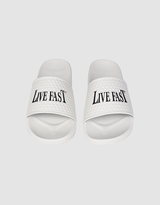 The LFDY Slides by LIVE FAST DIE YOUNG feature white PU textured straps with “LIVE FAST” in bold black letters, a comfortable EVA sole, and model number LF2606-20682.