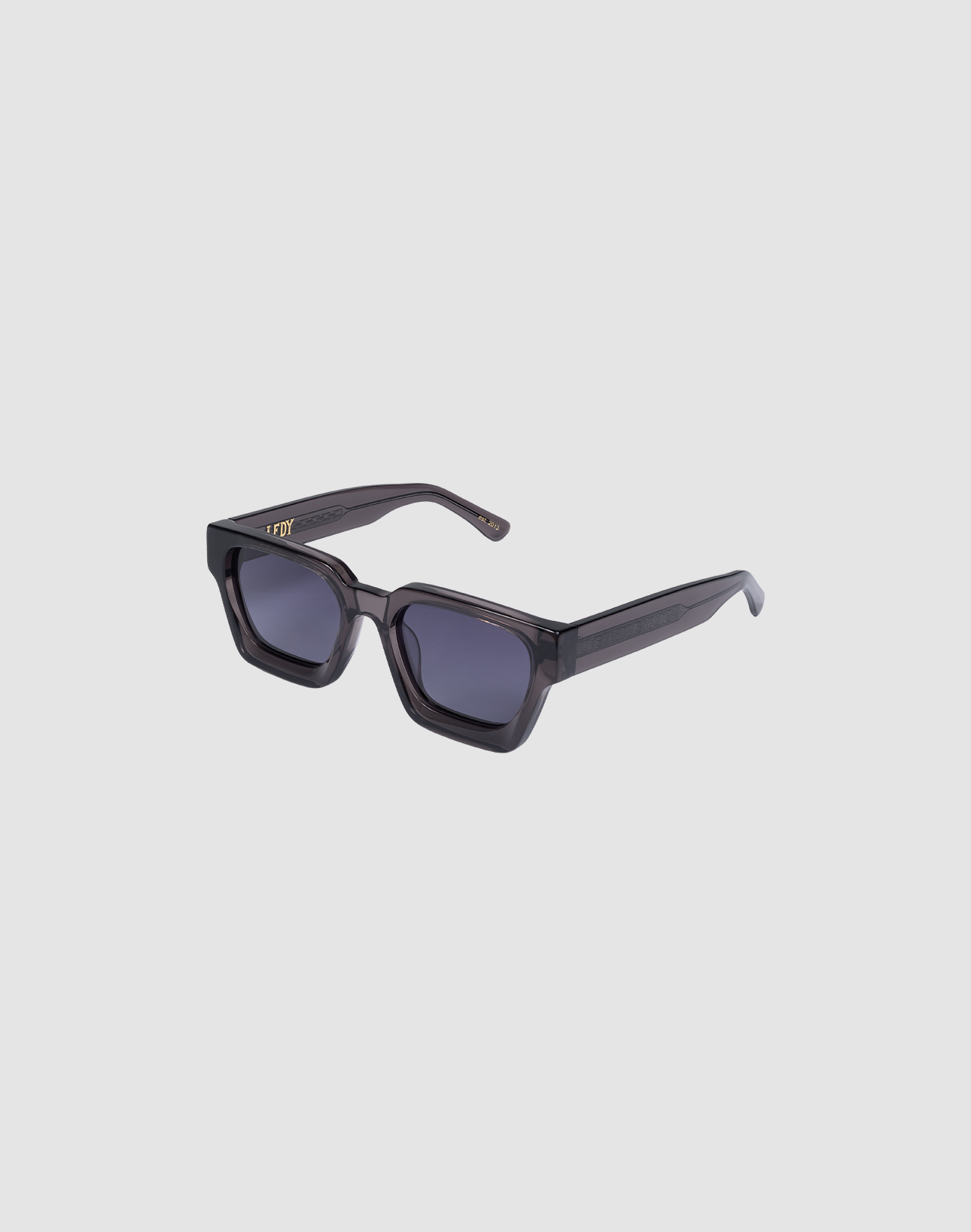 The LFDY Big Wire by LIVE FAST DIE YOUNG features black rectangular sunglasses crafted from premium Mazzuchelli acetate, with thick glossy frames, Facettenschliffe details, and dark UV-protective lenses on a light gray background.