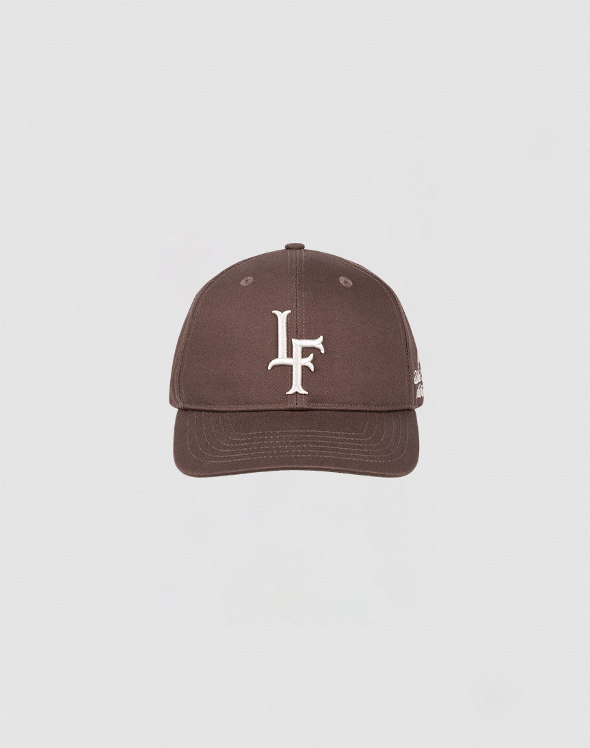 The LF Snapback by LIVE FAST DIE YOUNG is a brown baseball cap made from 100% Baumwolle, featuring a white LF logo embroidered on the front and a snap closure. It is centered against a plain light gray background.| plain