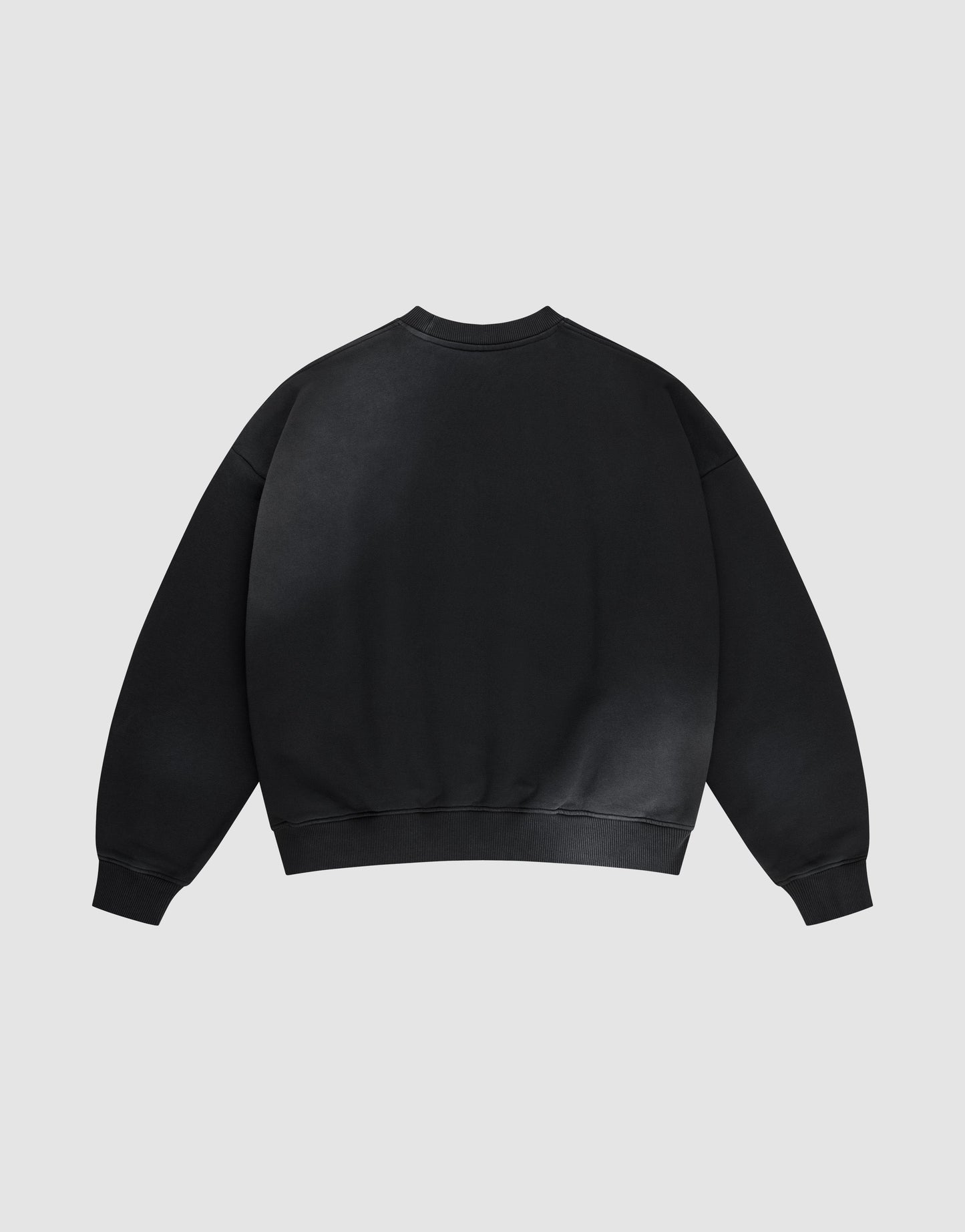 The LIVE FAST DIE YOUNG Live Fast Rhinestone Sweater, an oversized black crewneck with long sleeves and ribbed cuffs, collar, and hem, is laid flat and shown from the back against a light gray background.