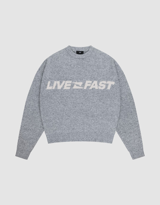 The Live Fast Boucle Sweater by LIVE FAST DIE YOUNG is a gray oversized knit with "LIVE FAST" in bold white letters across the chest, shown against a plain light background. | plain