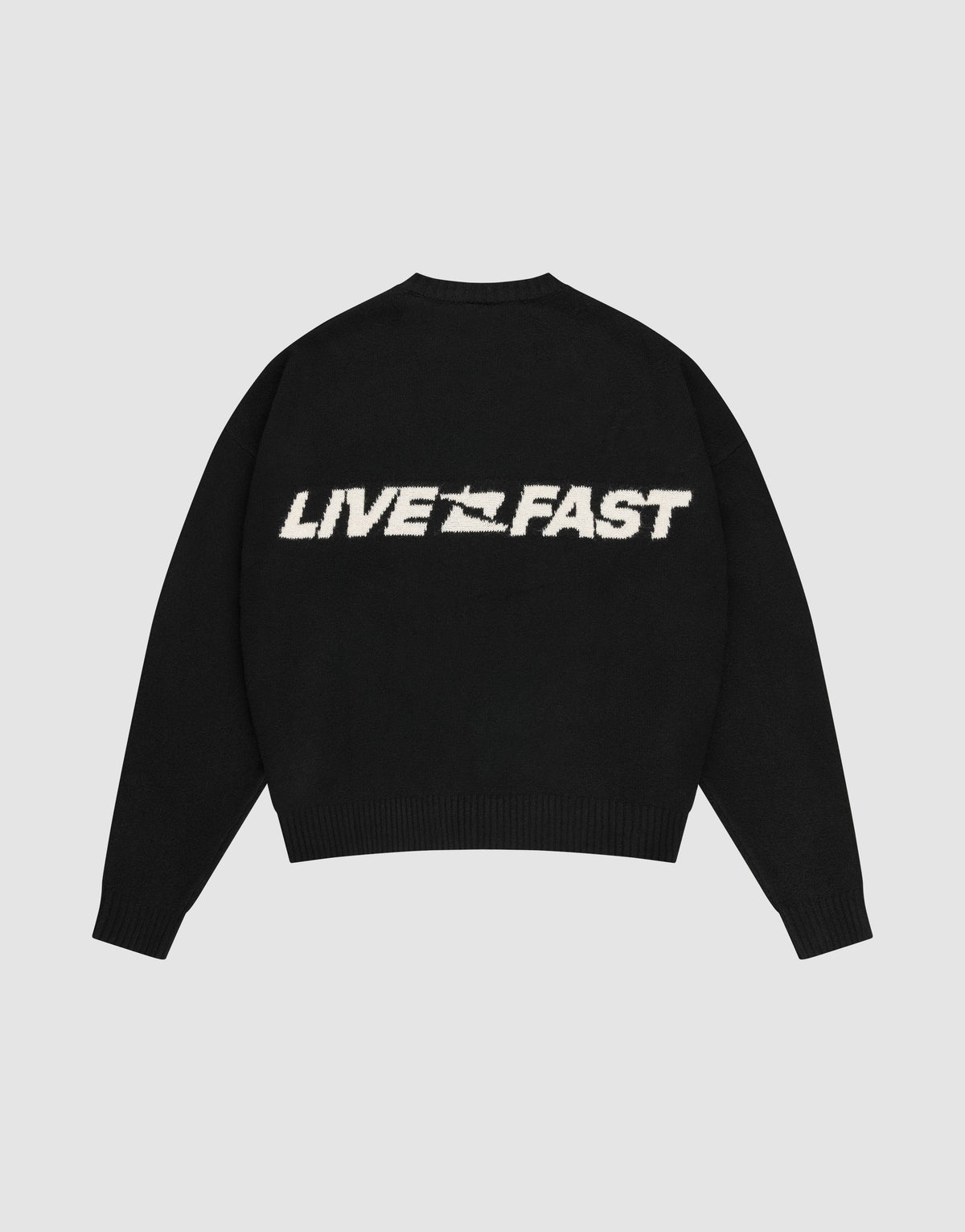 The Live Fast Boucle Sweater by LIVE FAST DIE YOUNG is a black, oversize-fit knit with "LIVE FAST" in bold white on the back, a stylized graphic between the words, and classic crew neckline plus ribbed cuffs and hem.