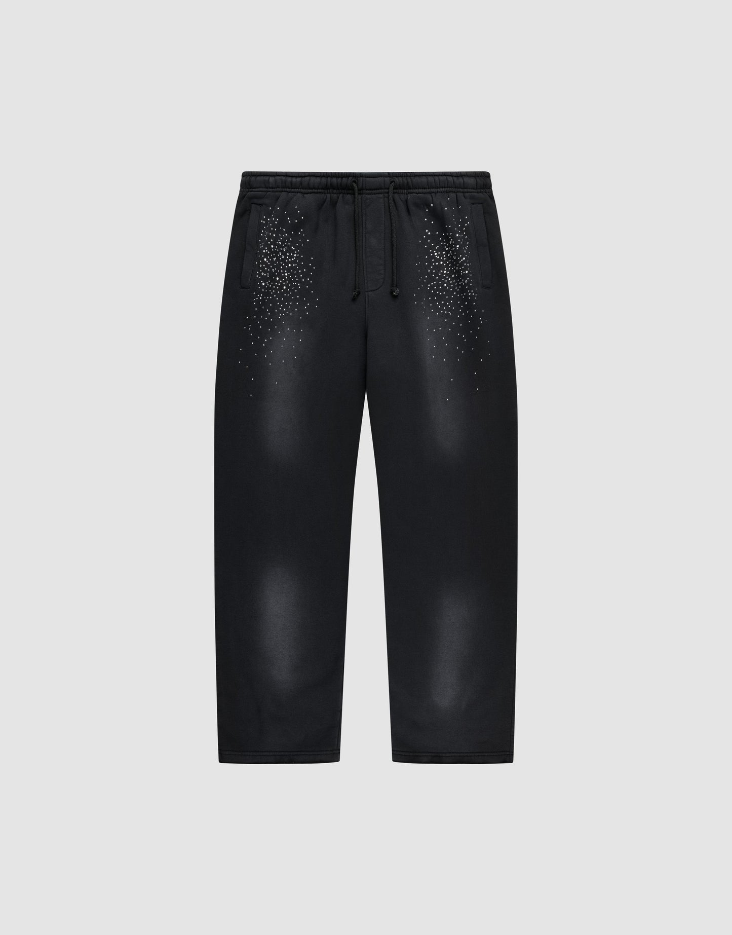 The LIVE FAST DIE YOUNG Live Fast Rhinestone Jogger is a black sweatpant with an elastic waistband and drawstrings, featuring a spray effect gradient and scattered small white dots on the upper front. Shown on a plain light gray background.