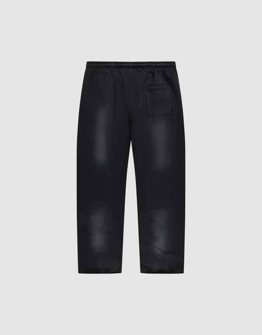 The Live Fast Rhinestone Jogger by LIVE FAST DIE YOUNG features a black wide fit, elastic waistband, spray effect faded areas, relaxed silhouette, and a single zippered back pocket. Shown against a plain light gray background.