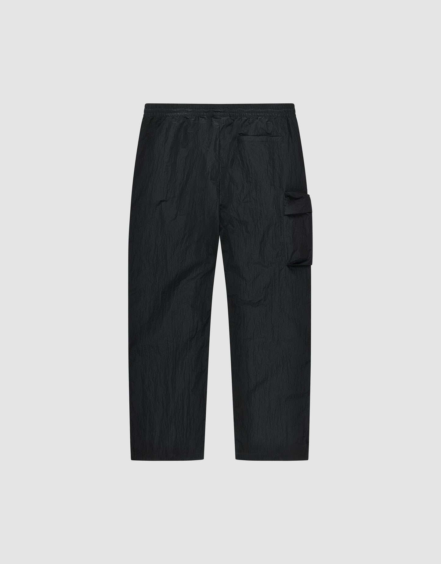 The Live Fast Nylon Pants by LIVE FAST DIE YOUNG are black cargo pants with an oversized fit, elastic waistband, and a single large zippered cargo pocket on the right thigh, shown on a plain light gray background.
