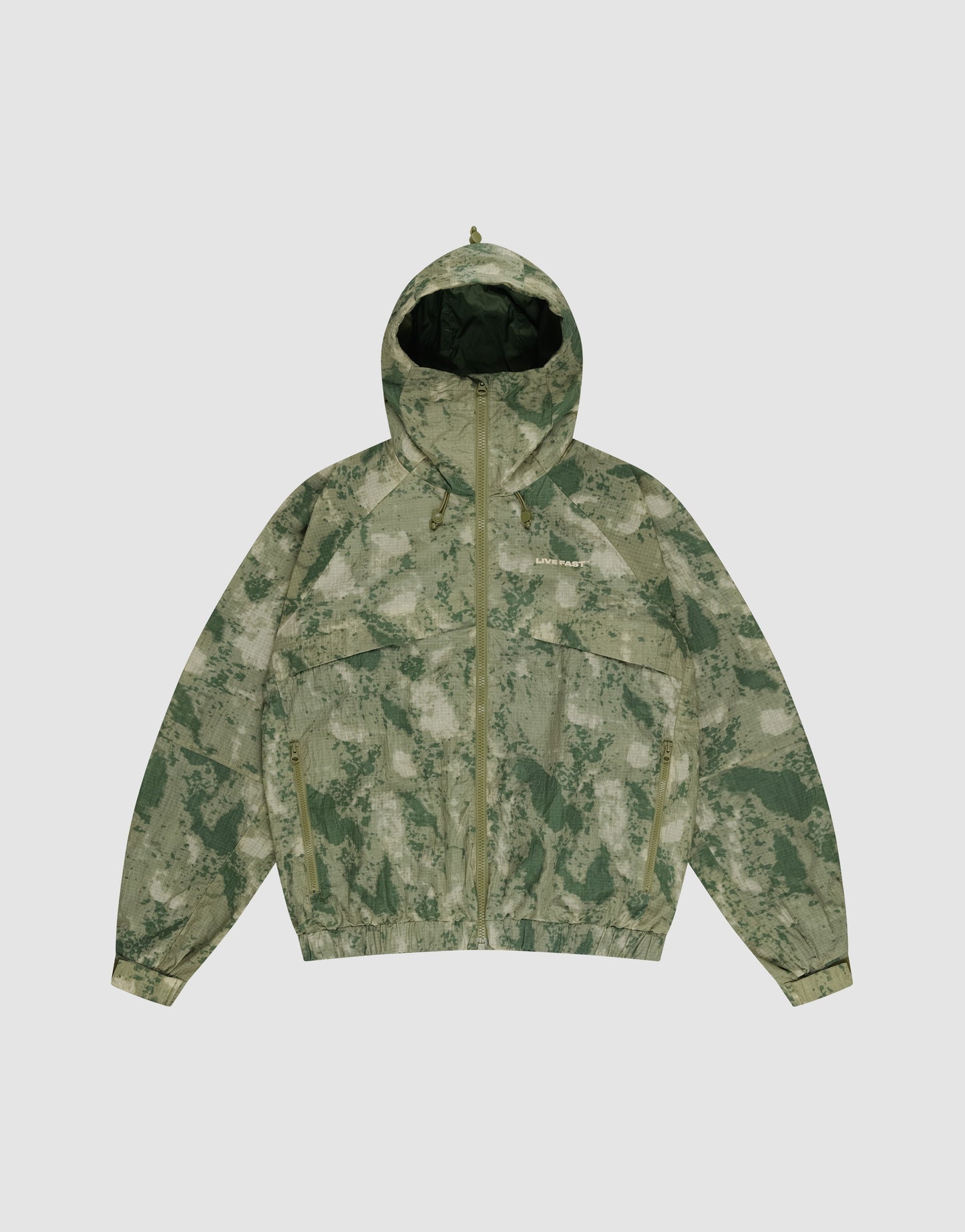 The Live Fast Nylon Jacket by LIVE FAST DIE YOUNG features a green and beige digital camo design, hood with drawstring, front zipper, elastic cuffs, and two large zip pockets, displayed flat on a light gray surface.