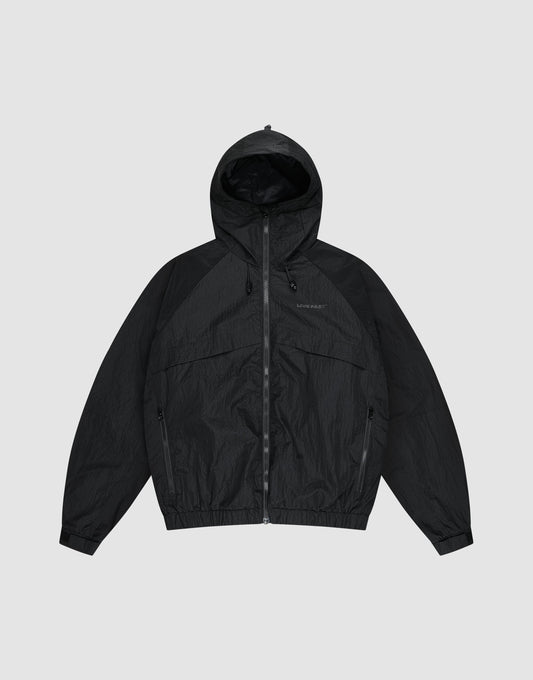 The LIVE FAST DIE YOUNG Live Fast Nylon Jacket is a black, oversized zip-up windbreaker with long sleeves, hood, Stehkragen, and side pockets, shown against a plain light gray background. | plain