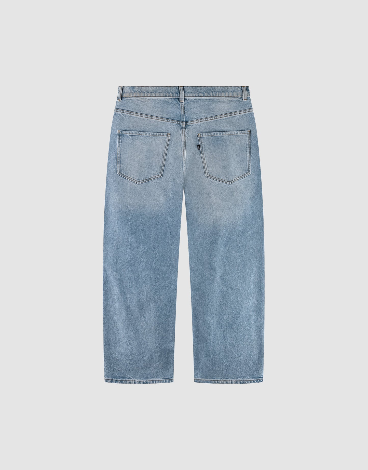 Back view of LFDY Baggy Denim by LIVE FAST DIE YOUNG in light blue with a baggy fit, wide straight leg, two back pockets, belt loops, and faded wash laid flat on a light gray background.