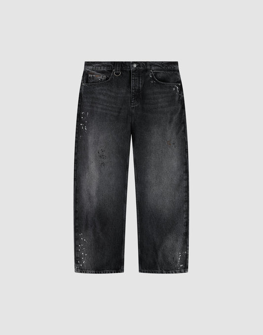 The LIVE FAST DIE YOUNG LFDY Baggy Denim is a pair of black jeans with a wide straight leg, baggy fit, faded wash, and white paint splatters, shown on a plain light gray background. | plain