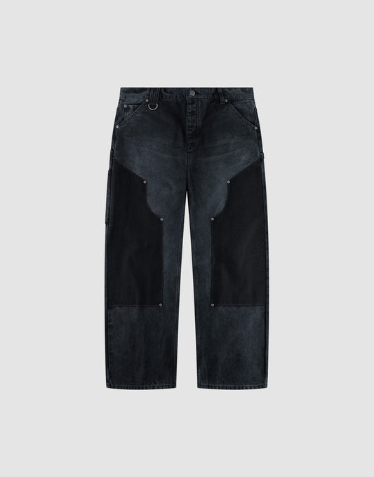 The LFDY Carpenter Pants by LIVE FAST DIE YOUNG feature a wide-leg, high-waist black denim design with dark charcoal thigh patches, silver rivet details, and are made from 100% Baumwolle. Shown on a light gray background. | plain