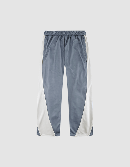 The LFDY DY Trackpants by LIVE FAST DIE YOUNG are wide fit, with a blue-gray center, white side panels, elastic waistband, and straight legs in polyester, shown on a light gray background. | plain