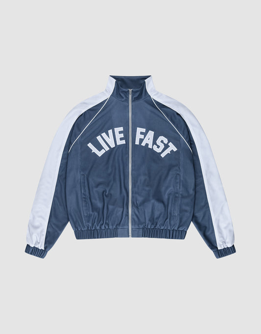 The LFDY Arch Trackjacket by LIVE FAST DIE YOUNG is a blue and white zip-up jacket with an oversize fit, featuring "LIVE FAST" in bold white letters across the chest and seitliche Eingrifftaschen for convenience. | plain