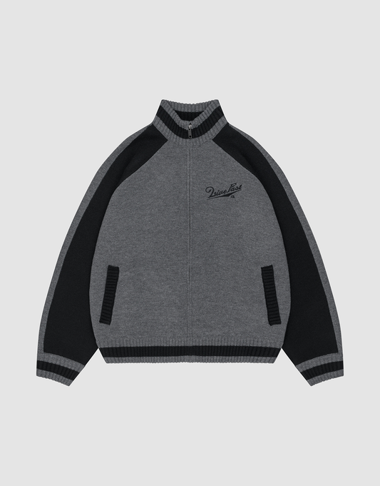 The LIVE FAST DIE YOUNG Boxy Knit Zip Jacket features gray and black intarsia-knit, raglan sleeves, ribbed collar, cuffs, and hem, black side panels, two front pockets, and embroidered cursive text on the left chest.