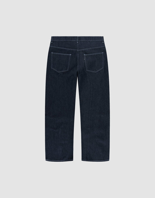 LFDY Baggy Denim by LIVE FAST DIE YOUNG in dark blue raw denim, shown from the back with wide straight legs, white stitching, and two rear pockets. Made from 100% cotton and displayed on a plain light gray background.