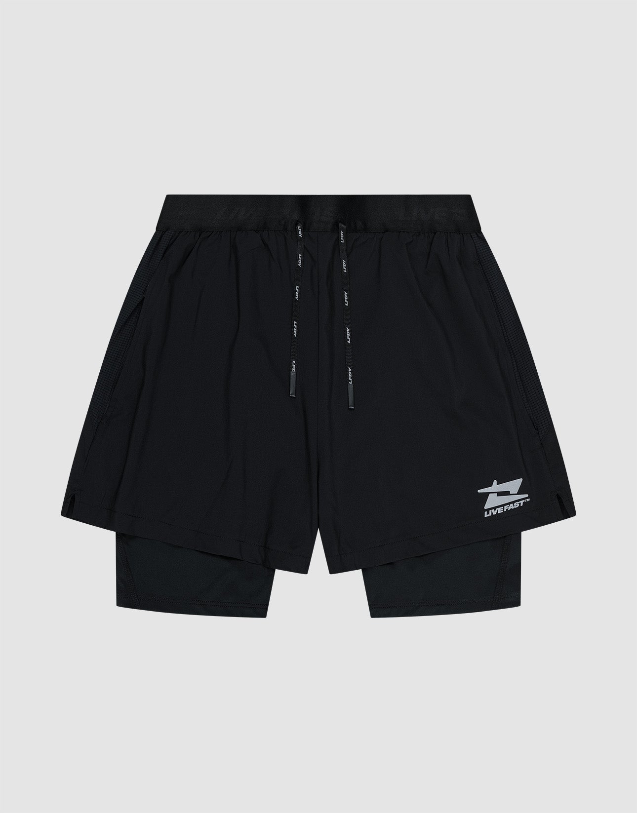 The LIVE FAST DIE YOUNG Live Fast Performance Running Shorts feature an overlapping design with built-in tights, elastic waistband with drawstrings, and a small white Live Fast Branding logo on the lower left leg, shown on a plain light gray background.