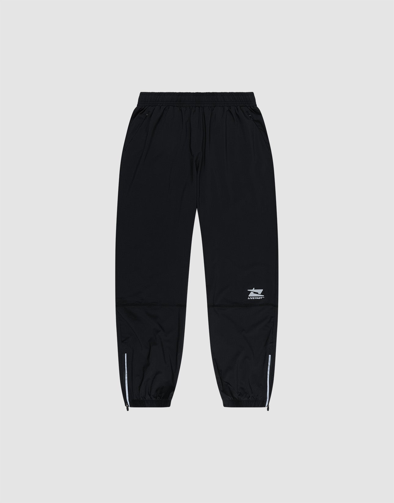 LIVE FAST DIE YOUNG’s Live Fast Performance Running Pants feature a black design with an elastic waistband, cuffed and zippered ankles, plus a small white logo on the left thigh, shown against a plain light gray background.