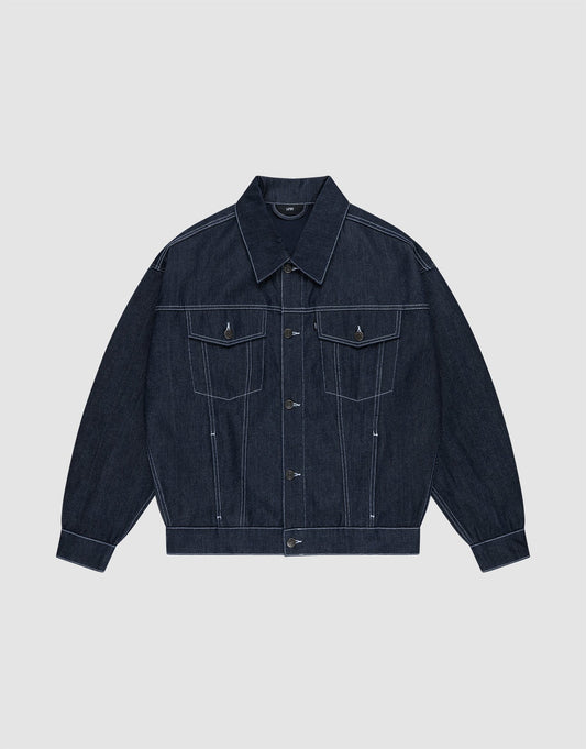 Die LFDY Denim Jacket von LIVE FAST DIE YOUNG aus 100% Baumwolle präsentiert sich in dunklem Raw-Denim mit spitzem Kragen, Knopfleiste, Brusttaschen mit Klappen und weißen Kontrastnähten auf hellgrauem Hintergrund. | plain