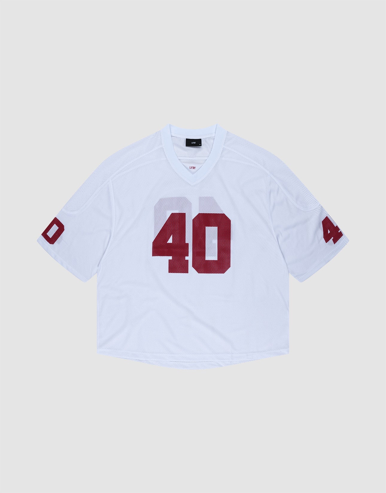 The LFDY Mesh Jersey by LIVE FAST DIE YOUNG is a white polyester football jersey with an oversize fit, short sleeves, and bold red number 40 on the front and sleeves. It features a V-neck collar and is shown on a light gray background.