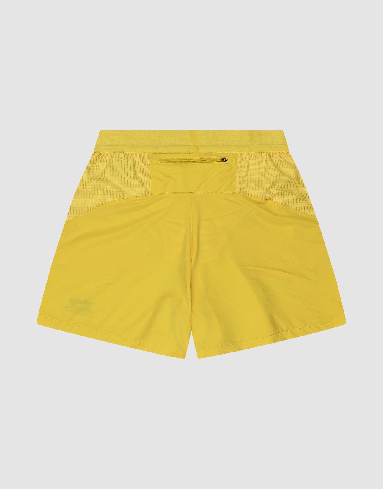 A man stands facing forward against a plain background, wearing LIVE FAST DIE YOUNGs bright yellow Live Fast Performance Shorts with Elastikbund and Reflektierender Print, paired with a matching tank top, white socks, and white sneakers. Hands behind his back.