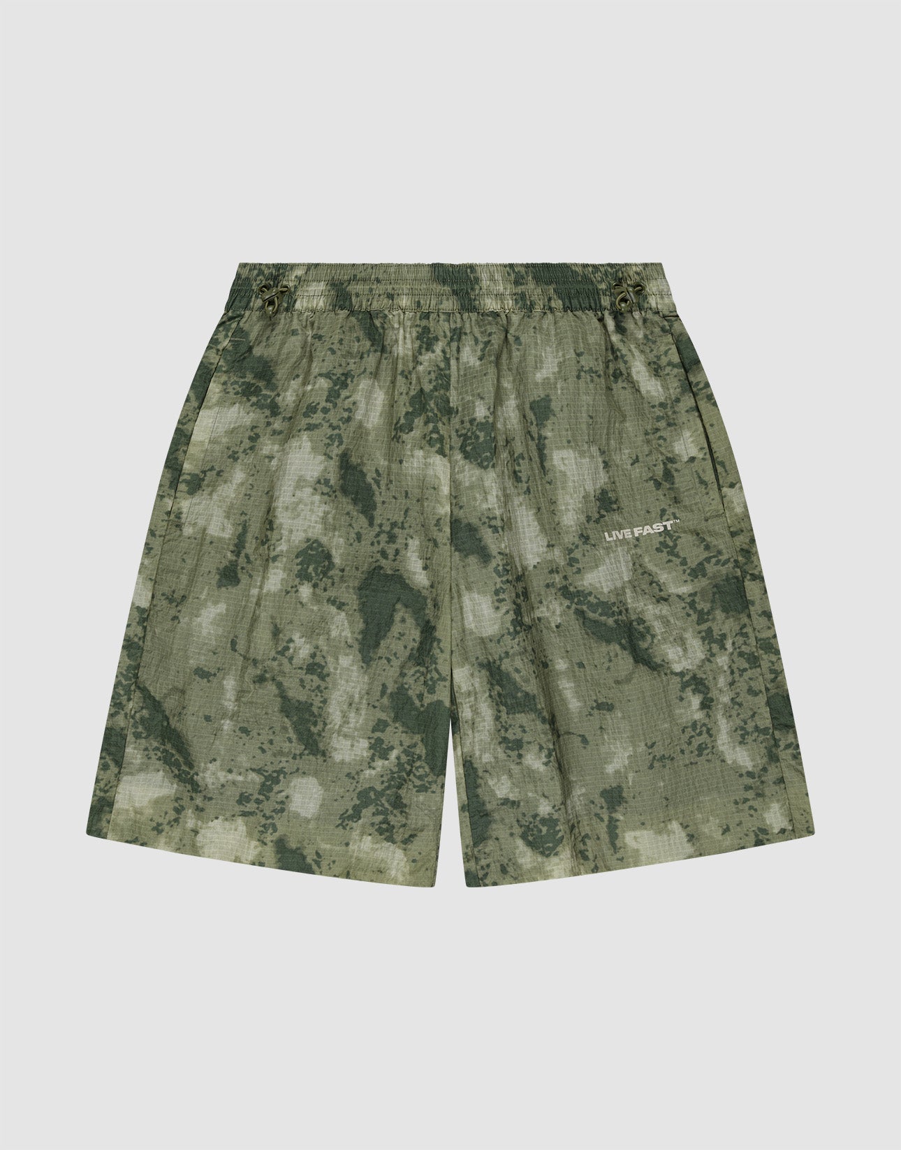 The LIVE FAST DIE YOUNG Live Fast Nylon Shorts feature a green camouflage pattern, elastic waistband, and subtle LIVE FAST silicone print on the right leg, displayed against a plain white background.