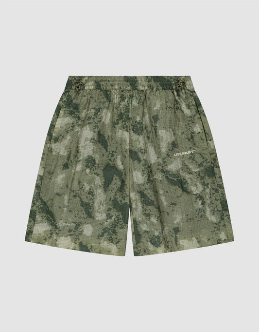 The LIVE FAST DIE YOUNG Live Fast Nylon Shorts feature a green camouflage pattern, elastic waistband, and subtle LIVE FAST silicone print on the right leg, displayed against a plain white background. | plain