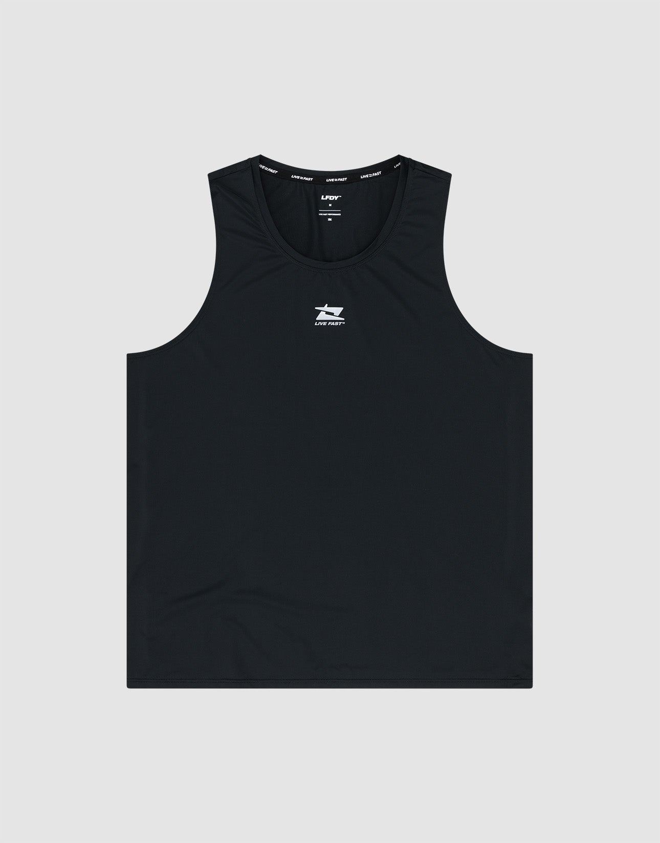 A man in a black LIVE FAST DIE YOUNG Live Fast Performance Tank, black shorts, white crew socks, and white sneakers stands against a white background with a serious expression and his left hand in his pocket.