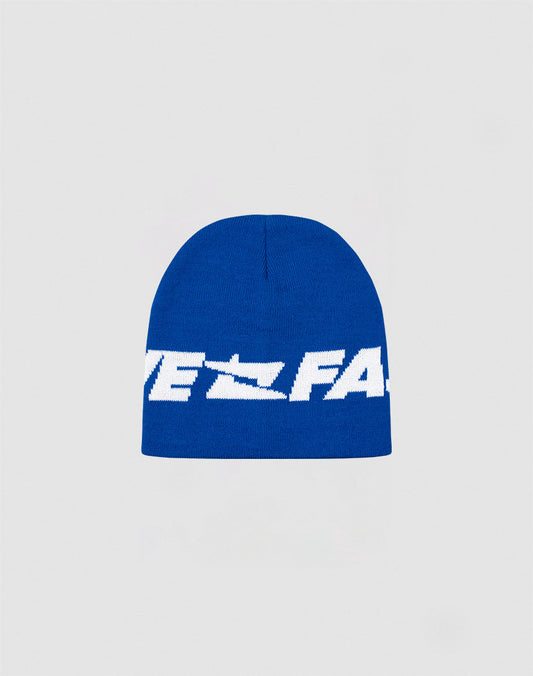 The Live Fast Jacquard Beanie by LIVE FAST DIE YOUNG is a blue knit polyacryl hat with bold white Logo Strick text across the front, shown on a plain light gray background. Style code: LF2410-16488. 