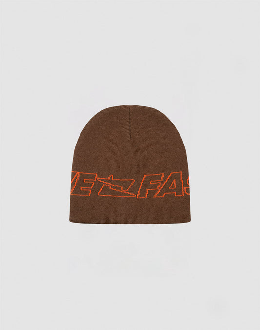 The Live Fast Jacquard Beanie by LIVE FAST DIE YOUNG is a brown 100% Polyacryl knit, featuring bold orange FAST lettering and a Logo Strick arrow design. Shown on a light gray background. Style code: LF2410-16485.