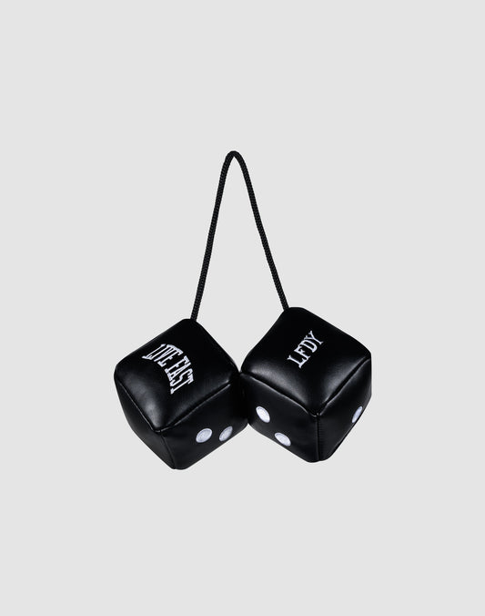 Two black LFDY Leather Car Dice by LIVE FAST DIE YOUNG, connected by a black string, hang from your rearview mirror. Both display "LEFTY" with white dots and lettering against a plain light gray background.| plain 
