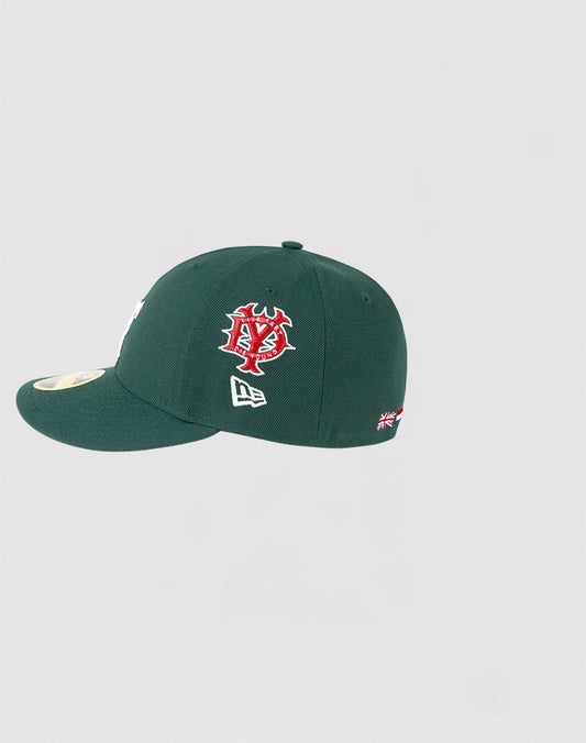 The LFDY x NEW ERA 59FIFTY Low Profile Cap by LIVE FAST DIE YOUNG features a dark green design, red and white side logo, small New Era icon, UK flag on the back, and gold sticker on the flat brim.