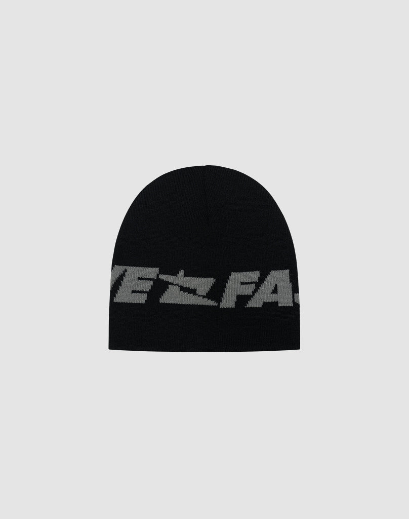The Live Fast Jacquard Beanie by LIVE FAST DIE YOUNG is black with a bold gray Logo Strick text wrapping the lower edge, made from soft Polyacryl. Shown on a plain light gray background. Model: LF2504-17542.