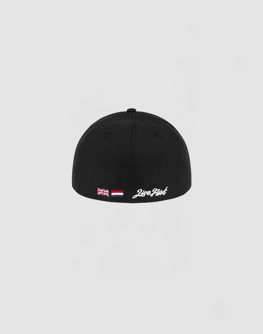The LFDY x NEW ERA 59FIFTY Low Profile by LIVE FAST DIE YOUNG is a black fitted cap with British and Indonesian flag patches and white 2wo Point text above the back edge, shown against a plain light gray background.